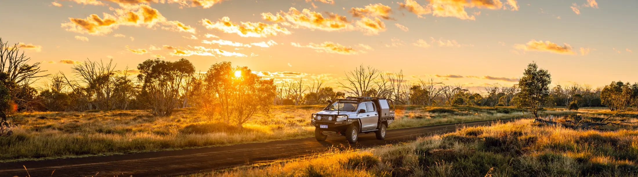 Toyota Hilux with ARB bar on an outback road at golden hour