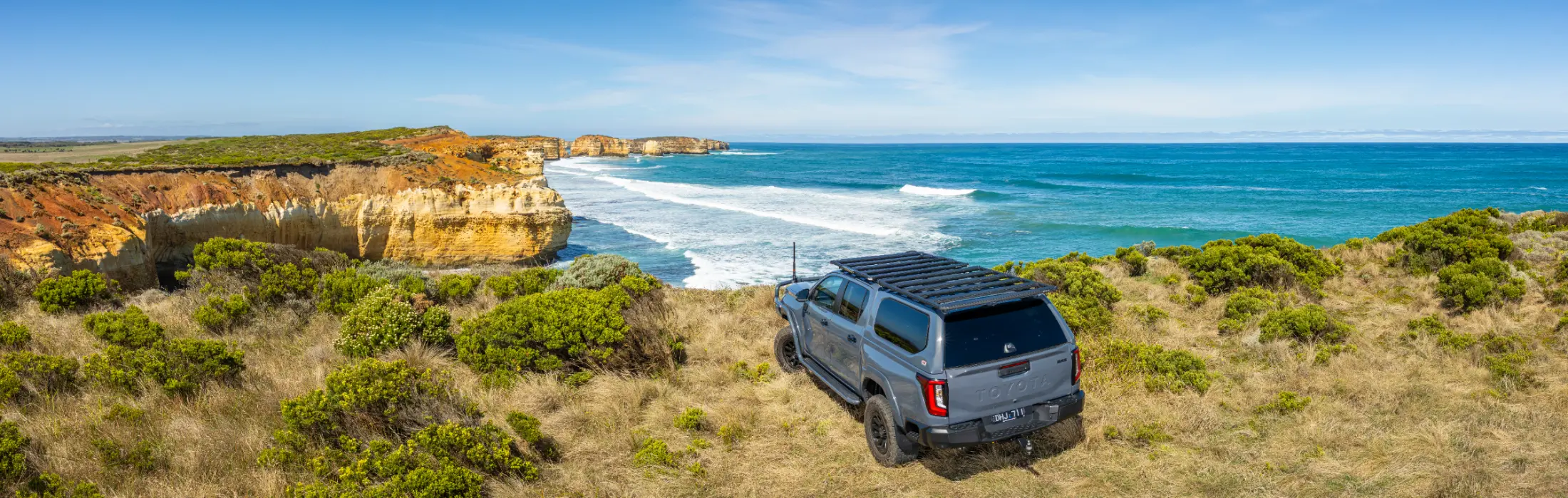 Toyota Hilux towing a boat on a beach at sunset